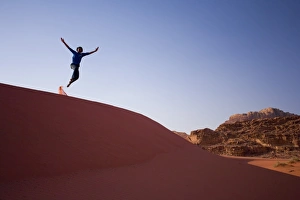 Person jumping off sand dune Person jumping off sand dune