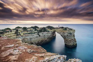 Person on Natural Sea Arch, Praia da Albandeira, Algarve, Portugal