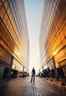 Tsim Sha Tsui Prints: A person stands through the golden Royal Pacific Hotel at sunset