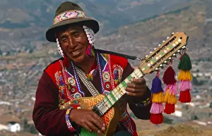 Peru, Cusco. An itinerant Quechuan musician plays his bandurria in the hills above Cusco