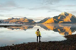 Rorbuer Prints: A photographer observes mountains and rorbuer in a Fjord during sunset