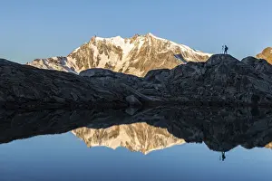 Lifestyles Prints: Photographer on rocks admiring Monte Rosa mirrored in water from Monte Moro Pass