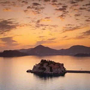 Montenegro Collection: The picturesque island village of Sveti Stephan illuminated at sunset, Sveti Stephan