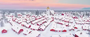 Rooftop Prints: Pink arctic sunrise over the snowy red cottages and bell tower in the old Gammelstad Church Town