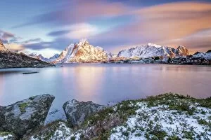 Images Dated 25th January 2016: The pink sky at sunrise illuminates Reine village with its cold sea and the snowy peaks