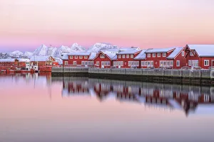 Pink sunset over the typical red houses reflected in the sea