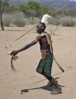 Pokot Collection: A Pokot warrior wearing a leopard skin cape celebrates an Atelo ceremony, spear in hand