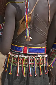 Jewellery Prints: A Pokot woman in traditional attire with patterned cicatrices on her back attends an Atelo ceremony