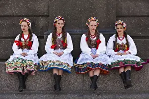 Market Square Prints: Poland, Cracow. Polish girls in traditional dress sitting at the base of the statue of Adam Mickiewicz