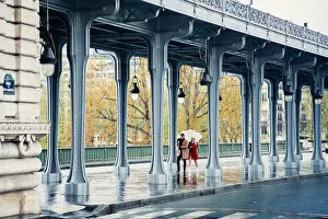 Umbrella Gallery: Pont de Bir Hakeim, bridge in Paris, France. Couple walking in a rainy day