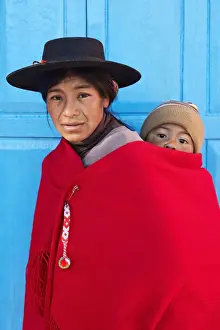 Portrait of an Aymara mother in traditional clothes with her child standing in front of