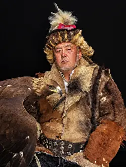 Attire Prints: Portrait of a Kazakh Eagle Hunter wearing traditional fur clothing and posing with his trained golden eagle