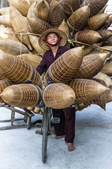 Bicycle Gallery: A portrait of a man on the bicycle loaded with the conical bamboo fish traps, near Hanoi