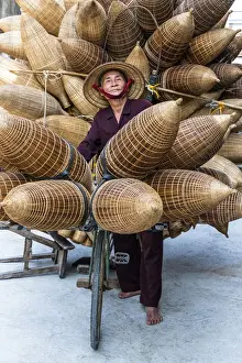 Craft Prints: A portrait of a man on the bicycle loaded with the conical bamboo fish traps, near Hanoi