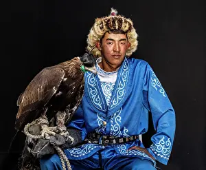 Mongolia Prints: Portrait of a young Kazakh Eagle Hunter posing with his trained golden eagle
