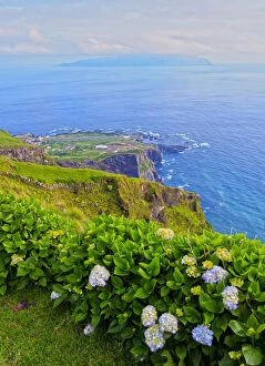 Portugal, Azores, Corvo, View of the shoreline towards Vila do Corvo with Flores Island
