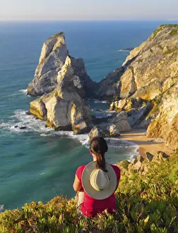 Portugal, Estramadura, Ursa woman sitting on cliff edge (MR)