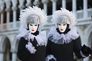 Two poseurs dressed as identical twins pose in St Marks Square during the Venice