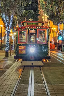 Powell and Market line cable car adorned with Christmas decorations by night, San Francisco, California, USA