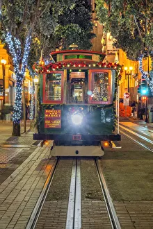 Images Dated 23rd March 2022: Powell and Market line cable car adorned with Christmas decorations by night, San Francisco