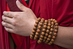 Prayer beads wrapped round the wrist of a red-robed monk near Mongar. There is a special religious significance in Prayer beads wrapped round the wrist of a red-robed monk near Mongar. There is a special religious significance in