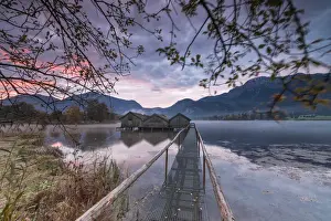 Kochelsee Prints: Purple sky at sunset and wooden huts are reflected in the clear water of Kochelsee