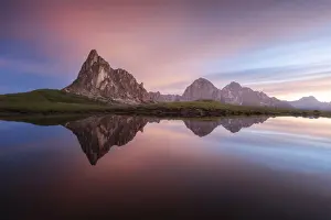The Ra Gusela and Tofane mountains in the Dolomites reflecting in a small puddle near the Giau Pass on a calm summer morning