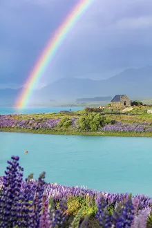 A rainbow over the church of the Good Shepherd and the lupins in bloom by the lake on a A rainbow over the church of the Good Shepherd and the lupins in bloom by the lake on a
