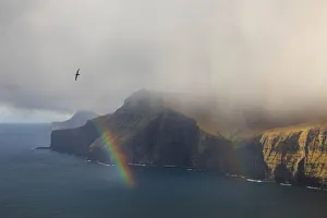 Cloudy Sky Prints: Rainbow along the coast of Eysturoy. Faroe Islands
