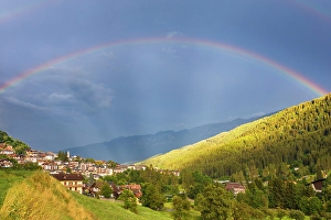 Rainbow over Mezzana village and Sun valley (val di Sole), Trento province, Trentino alto adige, Italy