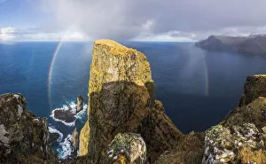 A whole rainbow above Risin og Kellingin sea stacks and Eiðiskollur, a 343 meter high cliff near the village of Eiði. Eysturoy, Faroe Islands