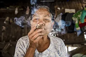 Rakhine State Prints: Rakhine state, Myanmar. Chin woman with traditional tattooed face smoking