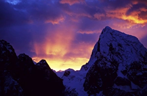 Everest Region Gallery: Rays of sunlight illuminate the clouds over the mountains