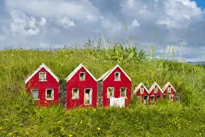 Red miniature Icelandic houses on green grass near Strandakirkja church, Selvogur, Reykjanes Peninsula, Iceland