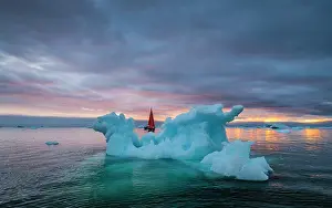 Danish Territory Prints: Red sailboat and blue iceberg at sunset in Disko Bay, Greenland