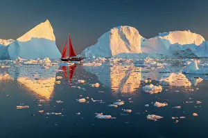 Danish Territory Prints: Red sailboat near icebergs in Disko Bay, Greenland