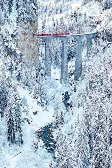 Railway Track Prints: Red train on famous Landwasser viaduct in the frozen snowy woods in winter