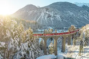 Railway Track Prints: Red train traveling in the winter snowy landscape from Filisur to Tiefencastel railway station