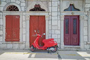 Aegean Prints: Red vespa scooter parked in front of a old building