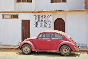 A red Volkswagen Beetle in front of a house in Puerto Eten, Chiclayo, Lambayeque, Peru