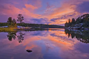 Reflection in Middle Lake at dusk Kenora, Ontario, Canada