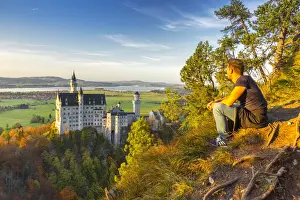 Resting and admiring panorama near Neuschwanstein Castle in Autumn at sunset. Schwangau