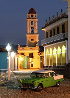 Classic Prints: Restored old American car parked in Plaza Mayor with the belltower of the Convent of San Francisco