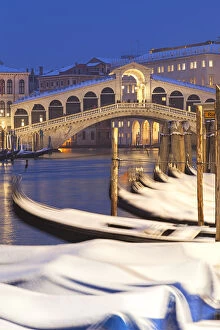 Rialto Bridge with snow-covered gondolas at dusk after a snowfall, Grand Canal, Venice