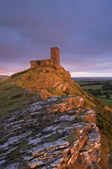 Rich evening sunlight illuminates Brentor Church in Dartmoor National Park, Devon