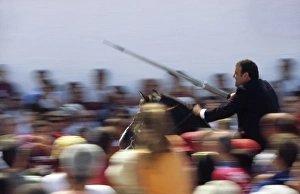 A rider on horseback speeds through the crowd attempting