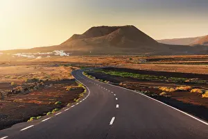Volcano Prints: The road that leads to the crater of Volcan de la Corona in the background during sunrise