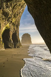 Rock cave and Elephant Rock in the background. Tongaporutu, New Plymouth district
