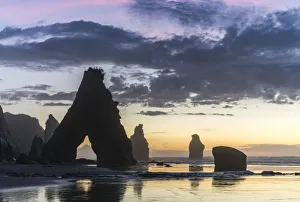 Rock reflect with low tide at the Three Sisters beach, at sunset, with Mt Taranaki