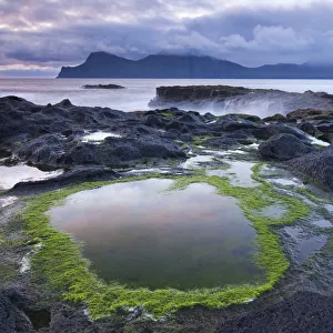 Rockpools on the shores of Gjogv on Eysturoy, looking towards the mountainous island